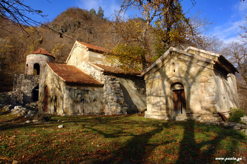 რკონის მონასტრის ეკლესიები შემოდგომის ტყის ფონზე